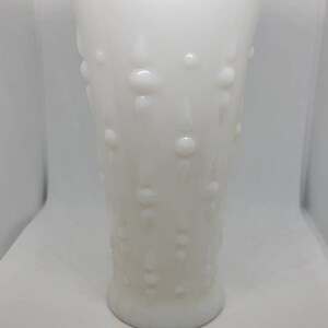 May include: A white milk glass vase with a scalloped rim and a textured design of raised dots and teardrop shapes.