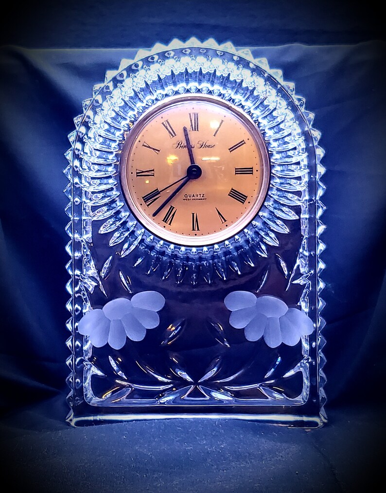 Grooves cuts surrounds clock face and has flowers frosted into below clock. West German made cut and frosted glass mantle clock