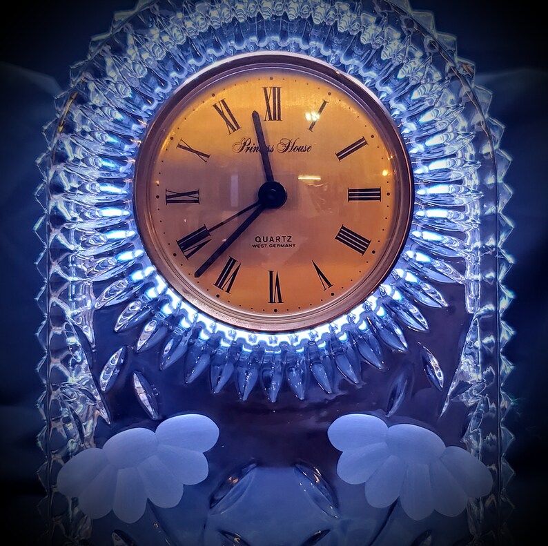 Grooves cuts surrounds clock face and has flowers frosted into below clock. West German made cut and frosted glass mantle clock
