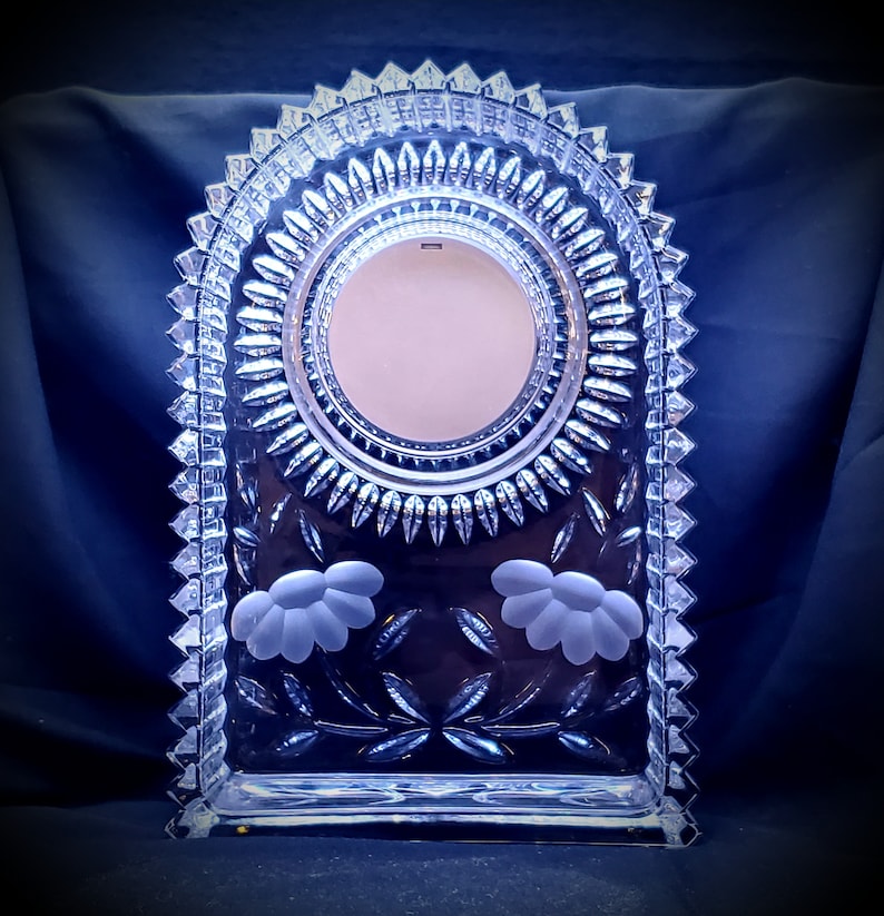 Grooves cuts surrounds clock face and has flowers frosted into below clock. West German made cut and frosted glass mantle clock