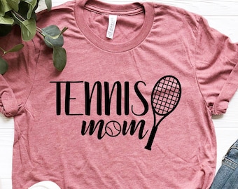 May include: A pink t-shirt with the text "Tennis Mom" and a tennis racket and ball graphic.