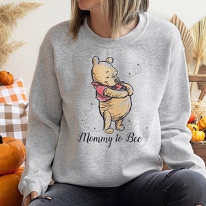 May include: A gray sweatshirt with a cartoon image of Winnie the Pooh and the text "Mommy to Bee".