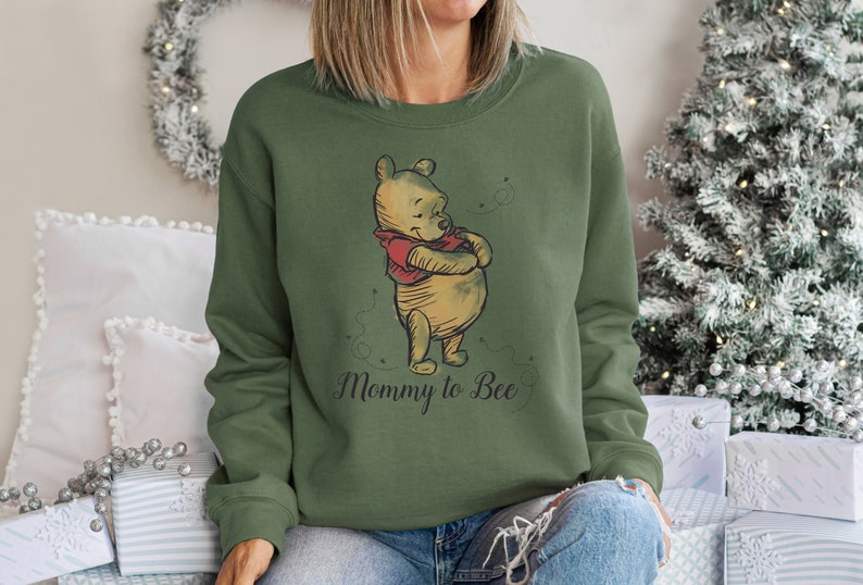 May include: A green sweatshirt with a Winnie the Pooh illustration and the text "Mommy to Bee".