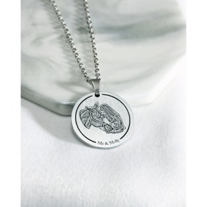 Pu&ograve; includere: Collana d'argento con un ciondolo rotondo che presenta un'immagine incisa in bianco e nero di una donna e un cavallo. Il ciondolo ha il testo "Me & Molly" inciso sul fondo.