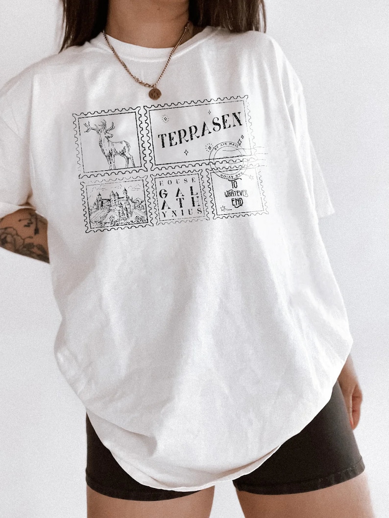 May include: White oversized t-shirt with a graphic print of four postage stamps. The stamps feature a deer, a castle, the words "TERRASEN" and "GOUSE GAL ATHE YNIUS", and the words "TO WHATEVER END".