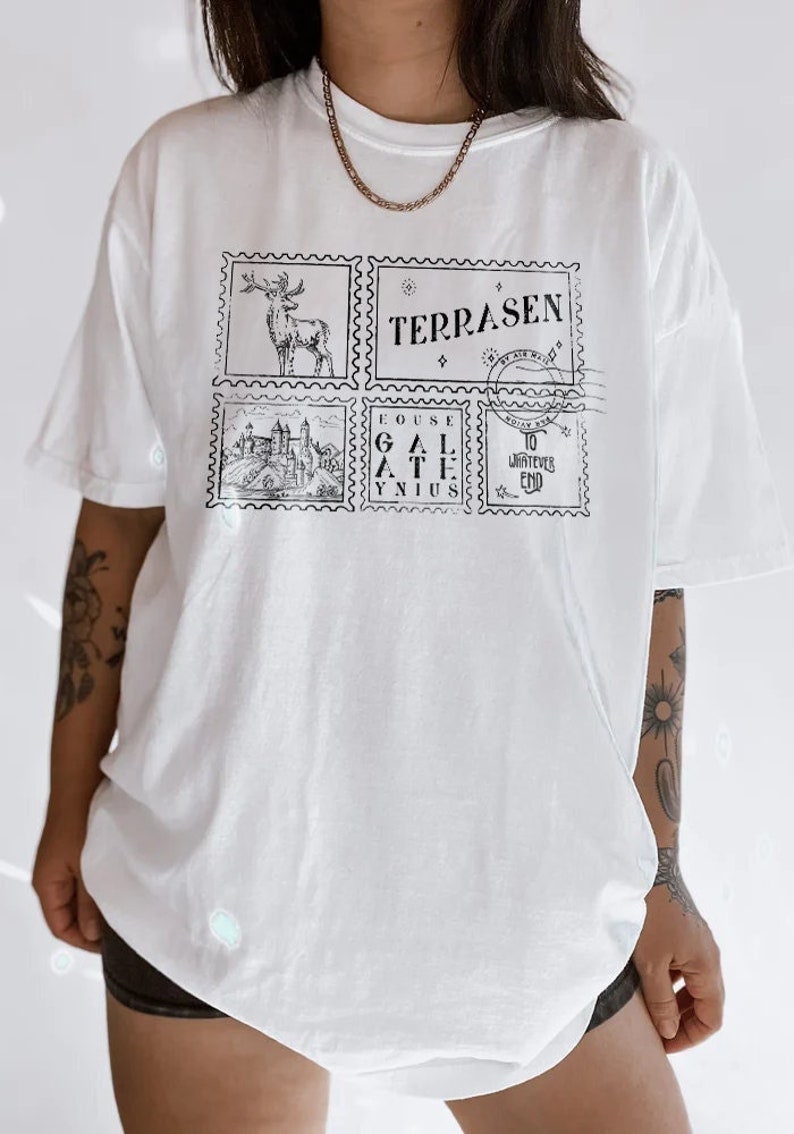 May include: White oversized t-shirt with a graphic print of four postage stamps. The stamps feature a deer, a castle, the words "Fouse Gal Athis Ynius", and the words "Terrasen By Air Mail" and "To Whatever End".