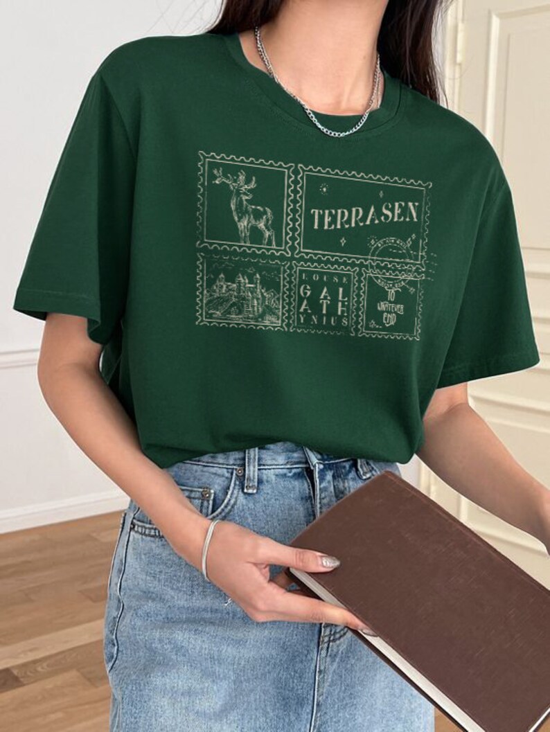 May include: Green short-sleeved t-shirt with a graphic print of four postage stamps featuring a deer, a castle, and the word "TERRASEN".