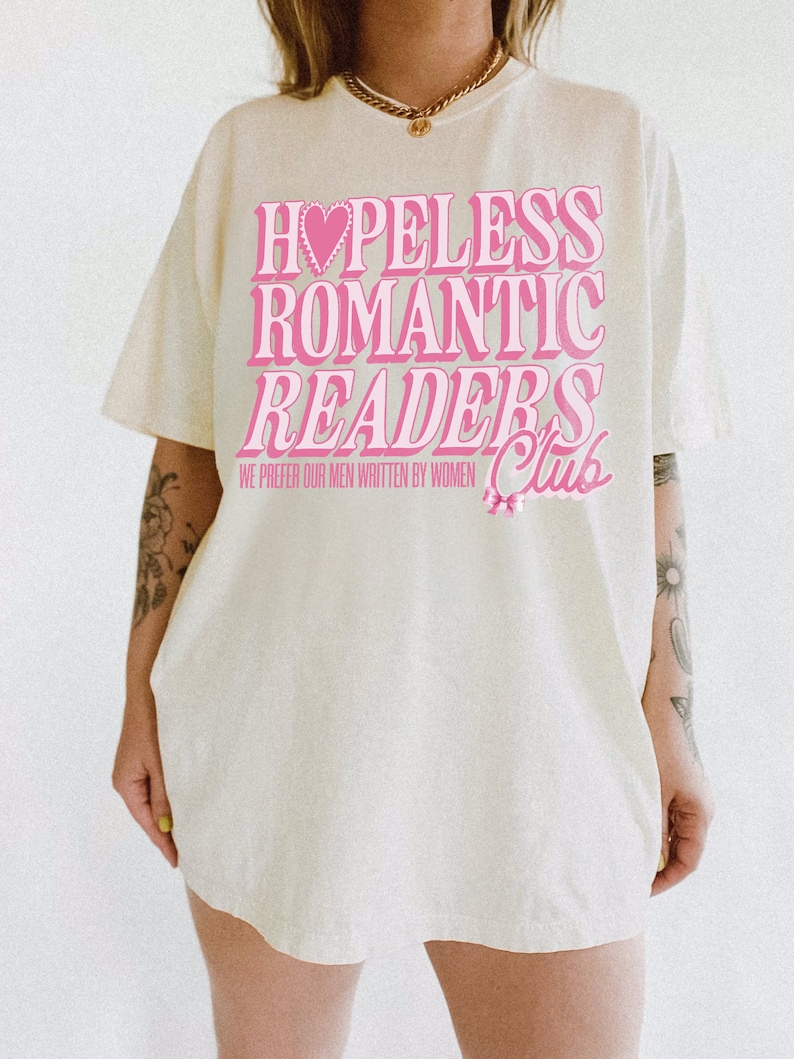 May include: A white t-shirt with a pink graphic that says "Hopeless Romantic Readers Club" with a pink heart and a pink bow. The text says "We prefer our men written by women."