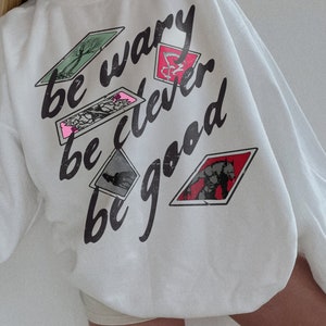 One Dark Window Sweatshirt | Be Wary Be Clever Be Good Licensed Shepherd King by Rachel Gillig Merch Elspeth Spindle Rayvn Yew Blunder Merch White