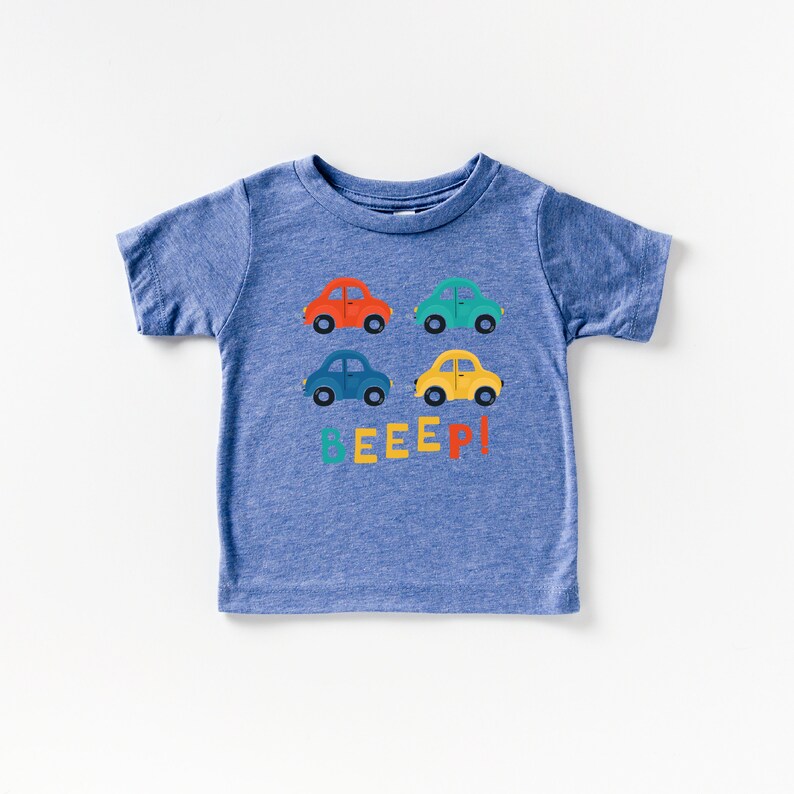 May include: A blue short-sleeved t-shirt with a graphic of colourful toy cars and the word "BEEEP!" printed on the front.