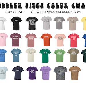 Op de afbeelding: Kleurenkaart van peuter-T-shirts in verschillende kleuren, waaronder wit, zwart, roze, oranje en blauw. De kaart toont de beschikbare kleuren en maten (2T-5T) voor Bella + Canvas en Rabbit Skins shirts.