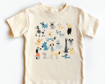 May include: A cream-colored short-sleeved t-shirt with a colorful illustration of various dogs in different poses and styles.