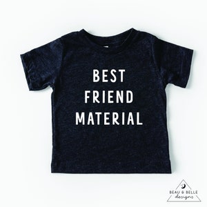 Può includere: Una maglietta grigia scura con testo bianco che dice "BEST FRIEND MATERIAL".