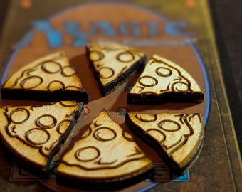 May include: Wooden pizza slices with a dark brown outline and light brown interior, arranged in a circle. Each slice has a dark brown circle design. The pizza slices are on a Magic card.