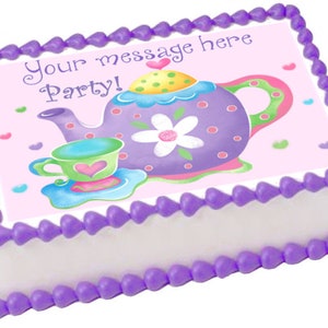 May include: Purple and pink teapot with a white flower and polka dots on a pink background with the text "Your message here Party!" on a white cake with a purple frosting border.