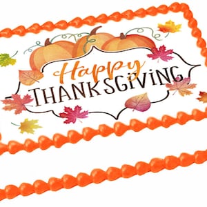 May include: A white cake with orange frosting and a Thanksgiving themed edible image. The image features two pumpkins, fall leaves, and the text "Happy Thanksgiving".