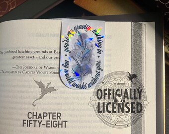 May include: A close-up of a book with the text "Chapter Fifty-Eight" on the page. A holographic sticker with a floral design and the text "you're my gravity, nothing in this world works without you." is on the page. A black and white stamp with the text "Officially Licensed" is on the page.
