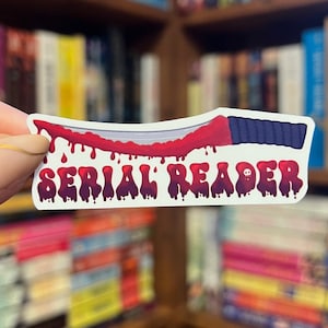 May include: A white sticker with a bloody knife and the text "SERIAL READER" in red dripping letters.