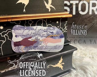 May include: A sticker with a quote from the book "House of Villainy" by V.E. Schwab. The quote reads "I am yours and you are mine, and there is no law or rule in this world of the next that will change that." The sticker is on a black book with a white dragon design.