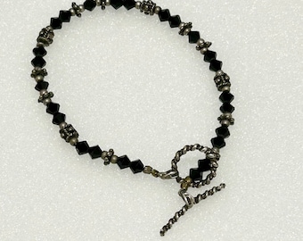 May include: A black crystal bracelet with silver accents and a silver clasp.