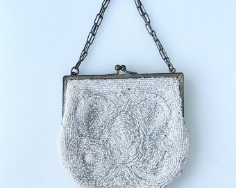 Bolso vintage Art Déco de los años 20 con bisagras, bordado con cuentas de semillas en color crema y blanco, con marco metálico con bisagras y cierre a presión. Medidas: 11,4 cm x 10,2 cm.