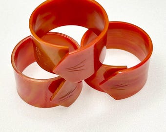 Zestaw trzech uchwytów na serwetki z bakelitu w kolorze marmurkowym w kolorze pomarańczowym