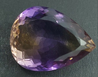 May include: A teardrop-shaped gemstone with a gradient of colors from yellow to purple. The gemstone is faceted and has a high polish.