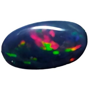 May include: A polished, oval-shaped black opal gemstone. The opal displays vibrant flashes of color, including red, green, and yellow, against a dark background. The gemstone is smooth and reflective.
