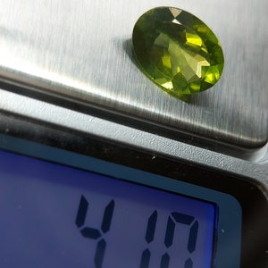 Peut inclure: Une pierre pr&eacute;cieuse verte pesant 4,10 carats sur une balance num&eacute;rique.