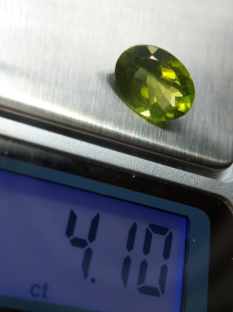 Peut inclure: Une pierre pr&eacute;cieuse verte pesant 4,10 carats sur une balance num&eacute;rique.