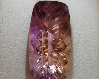 May include: A large, faceted, purple and pink gemstone with a rectangular shape.
