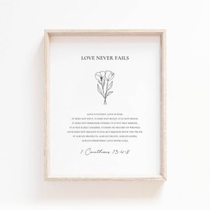 Op de afbeelding: Een zwart-witte printbare kunstprint met een minimalistisch bloemenontwerp en een citaat over liefde uit 1 Korintiërs 13:4-8. Het citaat luidt "De liefde faalt nooit".