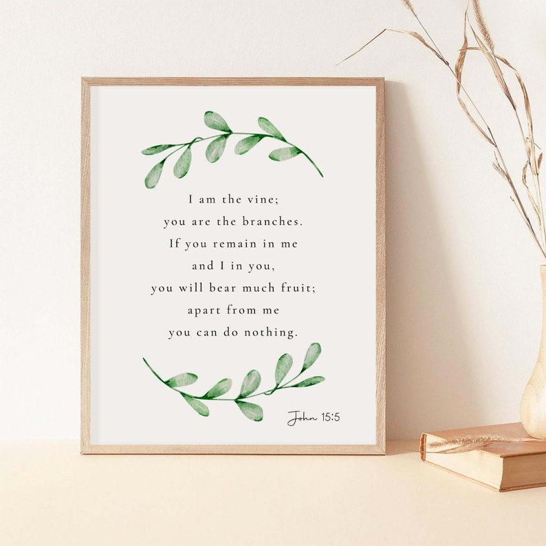May include: A framed print featuring a watercolour illustration of green leaves and a quote from the Bible, John 15:5. The quote reads: "I am the vine; you are the branches. If you remain in me and I in you, you will bear much fruit; apart from me you can do nothing."