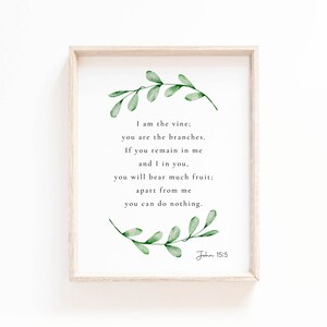 May include: A framed print featuring a watercolour illustration of green leaves and a quote from the Bible, John 15:5, which reads: "I am the vine; you are the branches. If you remain in me and I in you, you will bear much fruit; apart from me you can do nothing."