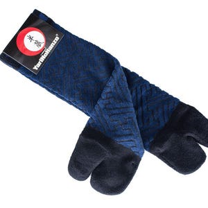 Puede incluir: Calcetines tabi azules y negros con un diseño de punta dividida. Los calcetines presentan un patrón geométrico y una etiqueta que dice "Yari-Moji Hanzo".