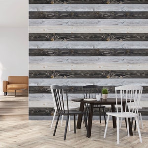 Könnte beinhalten: Ein Esszimmer mit einem Holztisch und Stühlen. Die Wand ist mit einer Holzplanken-Tapete mit einer abgenutzten weißen und schwarzen Oberfläche verkleidet.