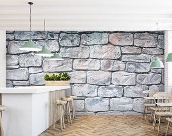 May include: A white counter with a white worktop and three wooden bar stools. The counter is in front of a wall with a stone brick pattern. Three green pendant lights hang from the ceiling above the counter.