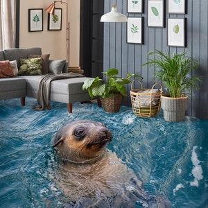 Puede incluir: Una foca nada en un océano azul con espuma blanca. El océano es un revestimiento de suelo 3D que parece realista. La foca es marrón y tiene la barriga blanca. La foca está mirando a la cámara.