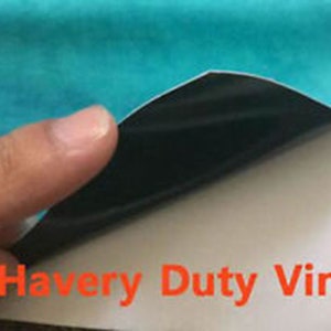 May include: Close-up of a turquoise vinyl sheet being peeled back to reveal a white backing with the text "Heavy Duty Vinyl" printed in orange.
