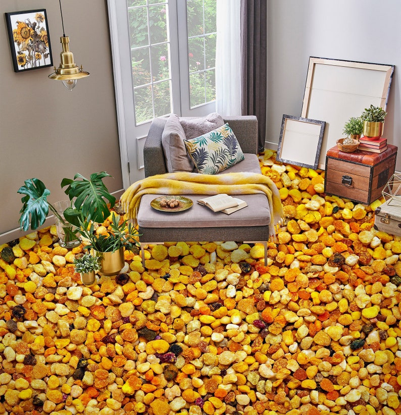 May include: A living room with a gray couch and a yellow blanket. The floor is covered in a thick layer of yellow and orange bee pollen.