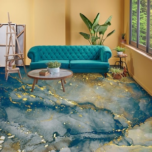 May include: A teal blue tufted sofa with a wooden coffee table in a living room with a blue and gold abstract patterned rug.