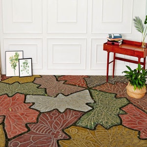 May include: A patterned floor with a design of overlapping butterfly wings in shades of red, green, brown, and gray. The floor is made of concrete or stone and has a rustic, vintage look.