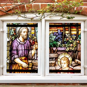 以下が含まれることがあります： 2 人の姿を描いたステンドグラスの窓。左側の姿は、あごひげを生やした男性で、紫色のローブを着て、ハンマーを持っています。右側の姿は、あごひげを生やした男性で、青いローブを着て、ハンマーを持っています。窓は白い枠に収められ、レンガで囲まれています。