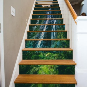 Puede incluir: Un conjunto de escaleras de madera con una escena de cascada y bosque impresa en cada escalón. La escena es un bosque verde exuberante con una cascada que cae por un acantilado rocoso.