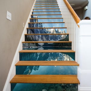 Könnte beinhalten: Eine Treppe aus Holz mit einem fotorealistischen Bergsee-Motiv, das auf jeder Stufe gedruckt ist. Die Szene zeigt eine Bergkette, die sich im Wasser spiegelt.
