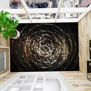 May include: A black and white floor covering with a swirling pattern of white lights. The floor covering is installed on a balcony with a view of a city.
