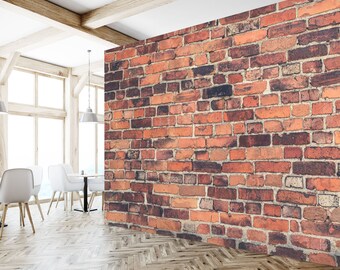 May include: A brick wall with red, orange, and brown bricks. The wall is in a room with a wooden floor and white walls.
