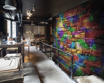 May include: A modern restaurant interior featuring a brick wall painted with colourful abstract designs. The wall is a focal point of the space, adding a vibrant and artistic touch to the room.