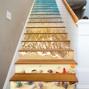 May include: A set of 10 decorative stair treads featuring a beach scene with blue water, sand, and seashells. The treads are made of a durable material and are easy to apply.