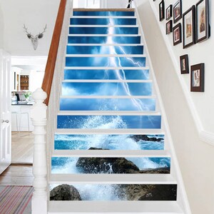 May include: A set of 10 stair treads with a blue sky and lightning bolt design on the top steps and a blue ocean wave crashing on rocks design on the bottom steps.